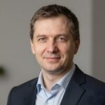 Профессиональный портрет уверенного российского бизнесмена на размытом фоне для сайта покерных соревнований